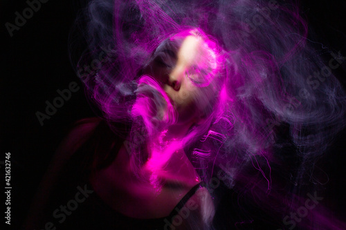 beautiful girl model with cosmic make-up on face, blue and purple color on dark background , longexposure foto