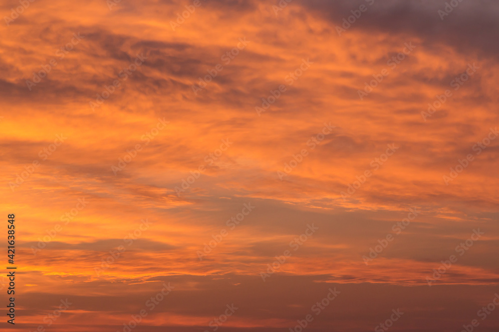 Epic Dramatic bright sunrise, sunset orange yellow red sky with clouds in sunlight background texture