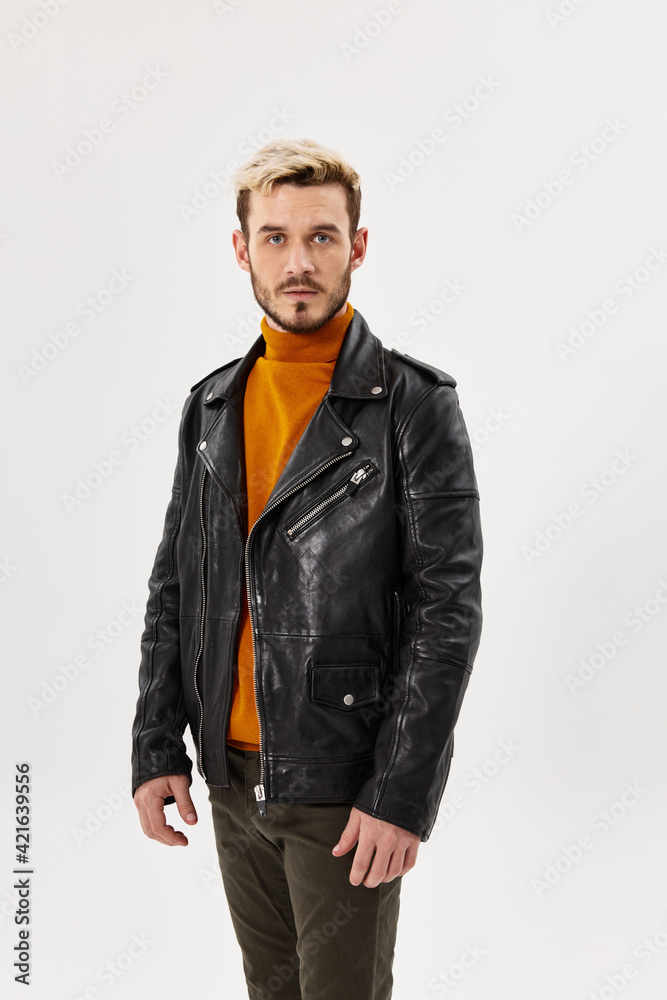 fashionable man in an orange sweater and in a leather jacket on a light background cropped view of the model fashionable man in an orange sweater and in a leather jacket on a light background cropped view of the model