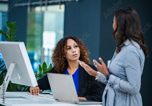 Two women talking in office photo