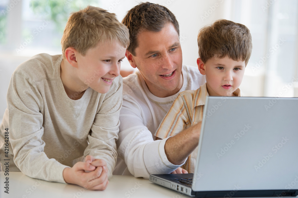 Father and sons looking at laptop Father and sons looking at laptop