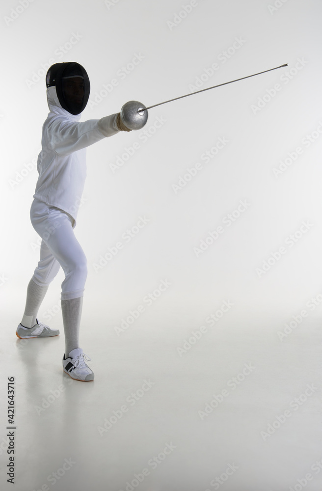 Studio portrait of fencer holding fencing foil Studio portrait of fencer holding fencing foil