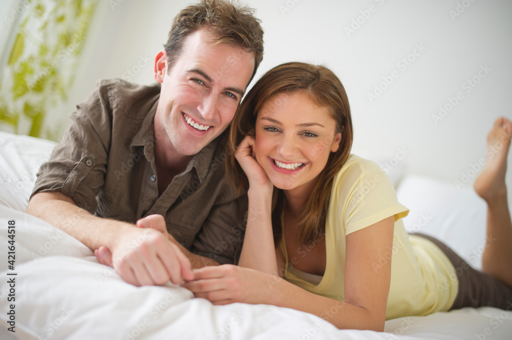 USA, New Jersey, Jersey City, Portrait of young couple lying on bed USA, New Jersey, Jersey City, Portrait of young couple lying on bed