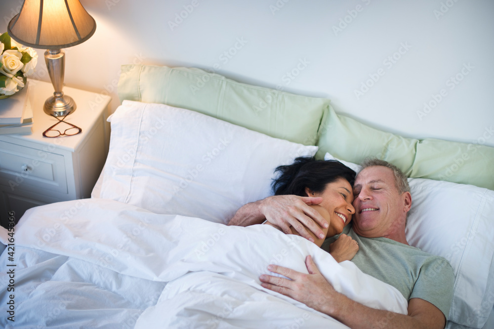 Happy mature couple laying in bed Happy mature couple laying in bed
