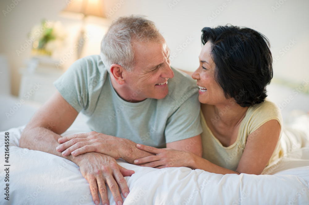 Happy mature couple laying in bed Happy mature couple laying in bed