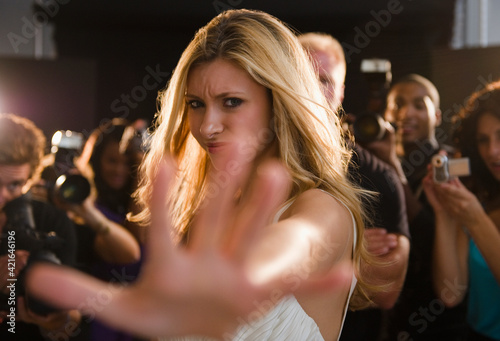 Celebrity blocking paparazzi at red carpet event