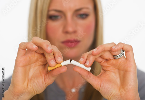 Young woman breaking cigarette photo