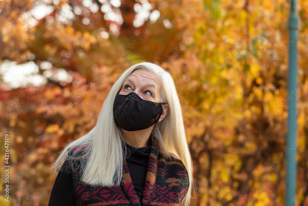 Portrait of senior woman wearing Covid protective mask outdoors in fall Portrait of senior woman wearing Covid protective mask outdoors in fall