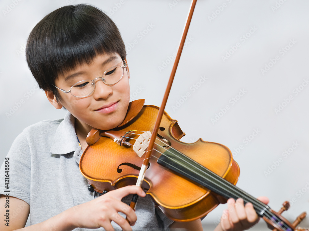 Elementary school student playing violin in music class Elementary school student playing violin in music class