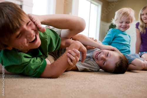 Children play fighting on floor photo