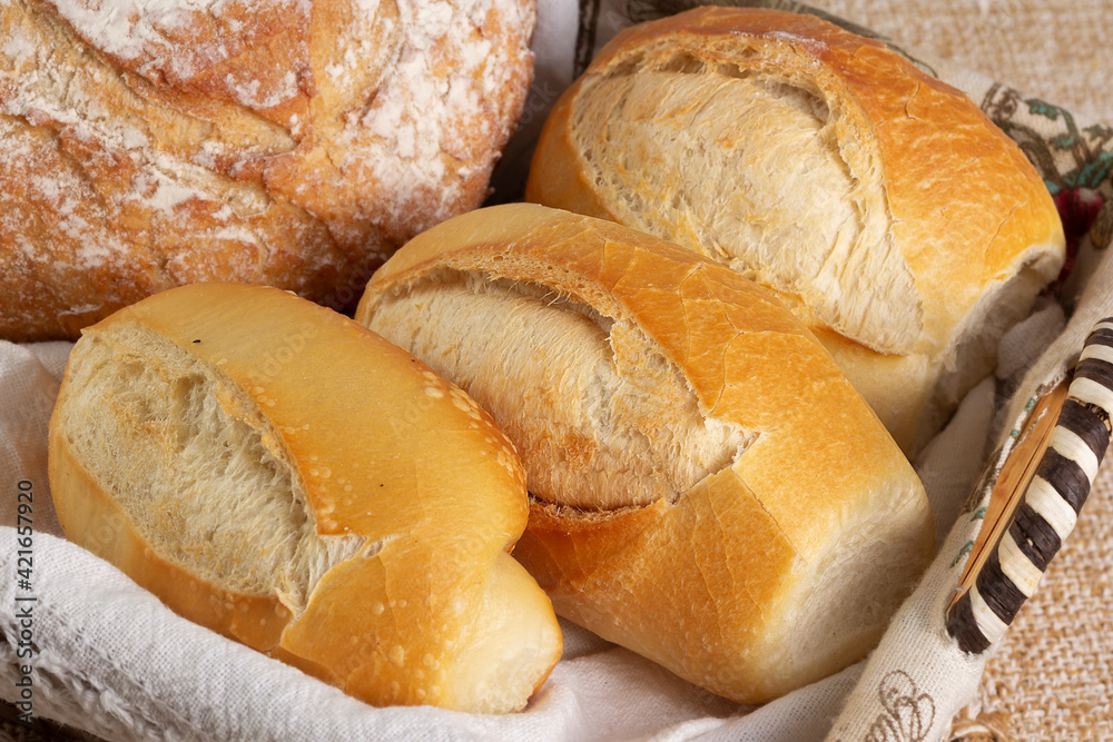 Closeup of basket with one Italian bread and three baguettes or french breads. 
