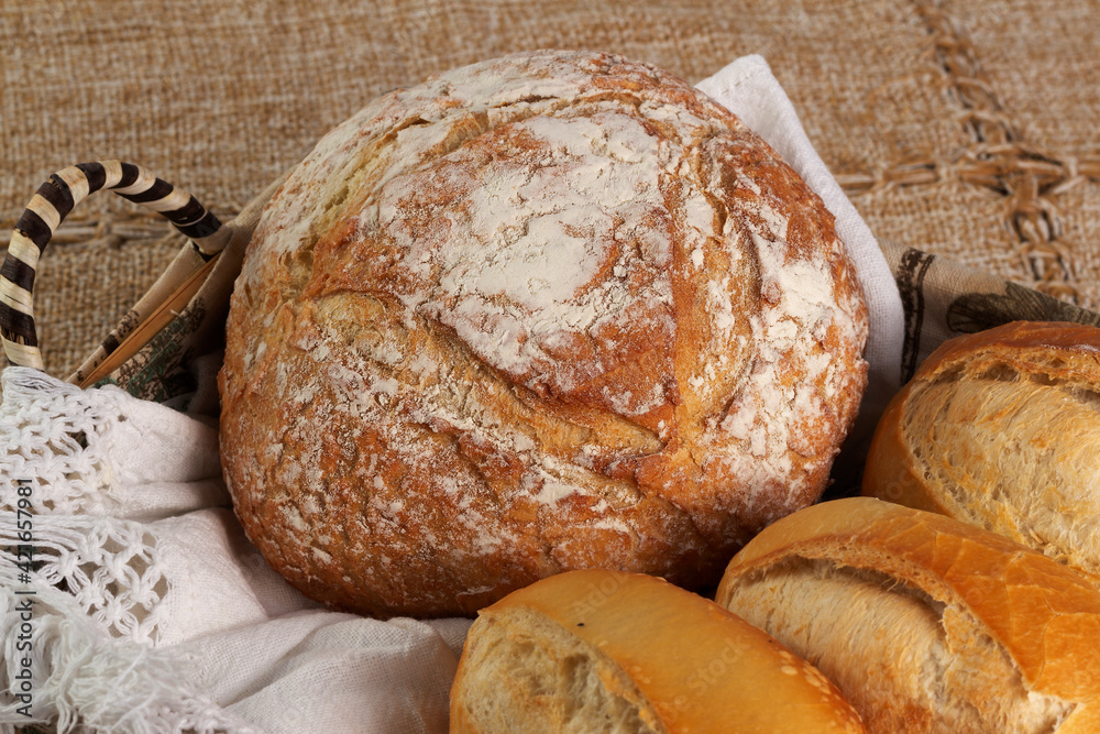 Closeup of basket with one Italian bread and three baguettes or french breads. 