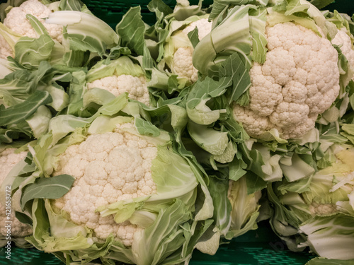 Vertical shot of fresh coliflower displayed in a market photo