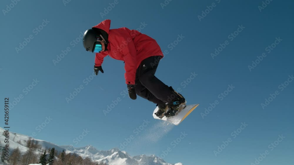 SLOW MOTION CLOSE UP: Extreme snowboarder jumping in big mountain ski resort. Detail of snowboard taking off the kicker in groomed snow park. Snowboarding jump on sunny winter day in snb park SLOW MOTION CLOSE UP: Extreme snowboarder jumping in big mountain ski resort. Detail of snowboard taking off the kicker in groomed snow park. Snowboarding jump on sunny winter day in snb park