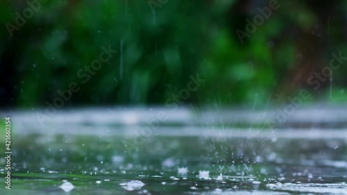 Rainy Day. Rain falling on wet asphalt and creating ripples. Macro shoot of Raindrop fall slow motion footage.