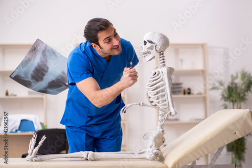 Young male doctor and skeleton patient in antismoking concept photo