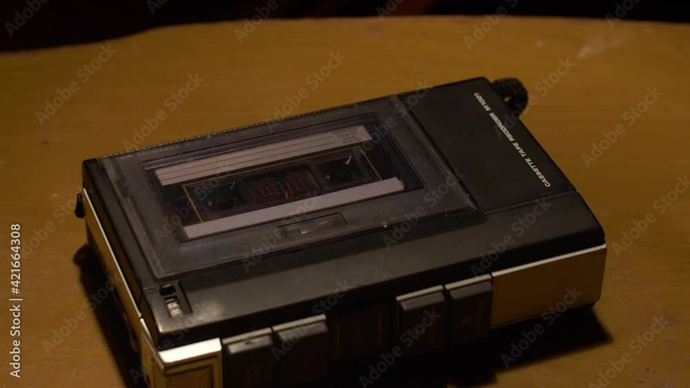 Tilt down shot of a vintage cassette player playing a tape