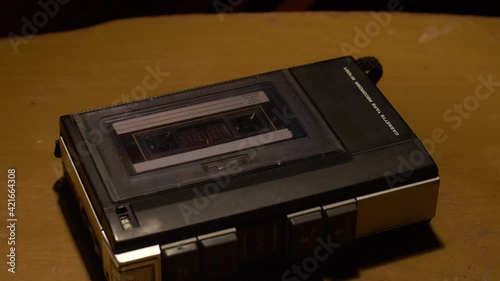 Tilt down shot of a vintage cassette player playing a tape