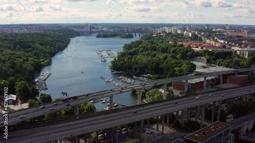 Stockholm, Sweden. Aerial Drone summer view of a beautiful lake and bay with bridges, near Södermalm with motorway, cars and jetty with boats.