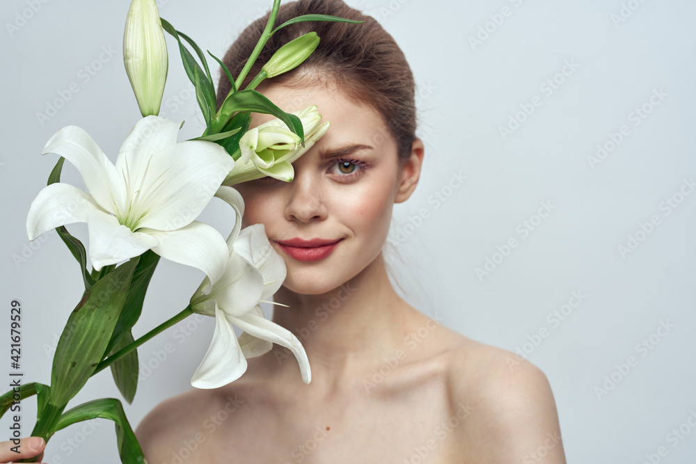 Lady with a bouquet of white flowers on a gray background portrait cropped view close-up Lady with a bouquet of white flowers on a gray background portrait cropped view close-up