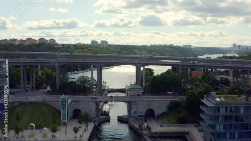 Stockholm, Sweden. Aerial Drone summer view of a lock with bridges, canal and bay at Hammarby Sjöstad with modern architecture, marina, and sailing boats.