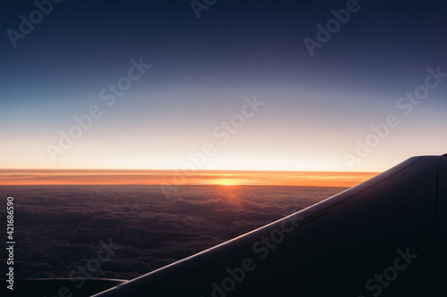 Airplane wing against the sunset sky