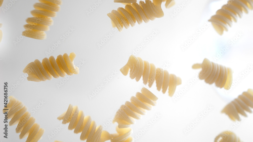 Macaroni of fusilli are falling on the glass, close up, food and ingredients, 4k Macaroni of fusilli are falling on the glass, close up, food and ingredients, 4k