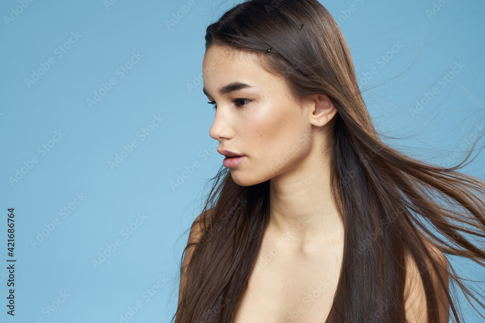 pretty brunette naked shoulders long hair skin care blue background