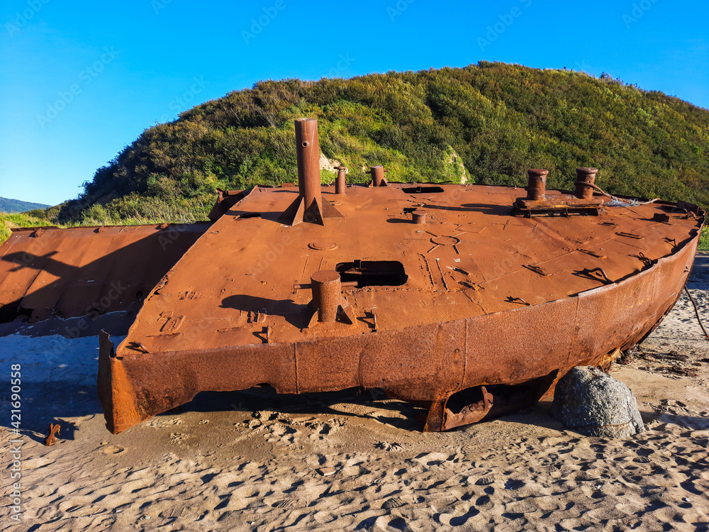 An old rusty ship thrown out on the seashore