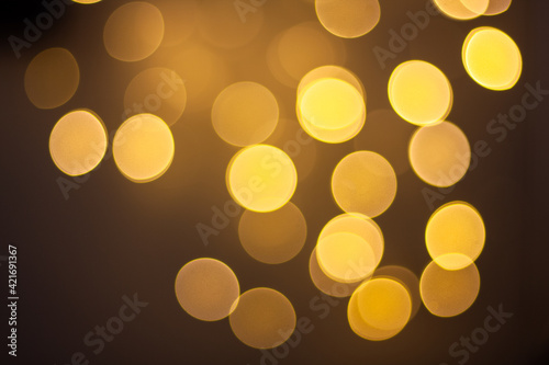 Abstract glitter defocus bokeh background with gold-yellow  light effect on circle theme background.