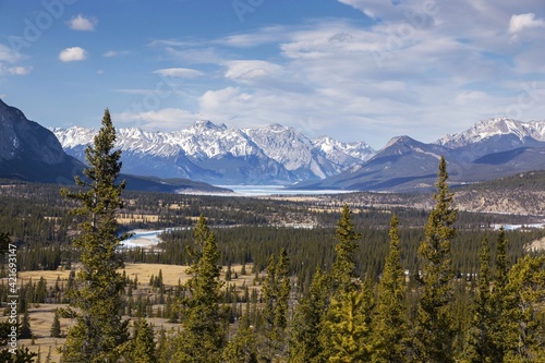 Scenic Aerial View of Kootenay Plains Ecological Reserve, Distant Abraham Lake and Rocky Mountain Peaks on Horizon. Sunny Early Springtime Day Landscape in Canadian Rockies
