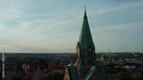 Panoramic aerial flying drone view of Södermalm, Sofia church tower, park, rooftops, buildings, and city from above. Stockholm, Sweden. 