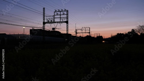 夕焼け空　菜の花畑　遠くから近づき去っていく電車（三重県多気郡明和町　近鉄山田線　漕代→斎宮間）	