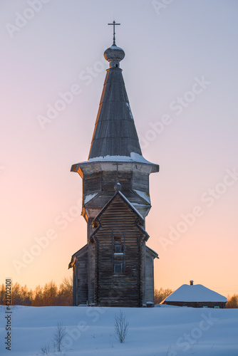 The old wooden church of Elijah the Prophet against the setting sky on a February evening. Saminsky Pogost. Vologda region, Russia photo