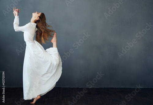 Romantic red-haired Woman in a white dress on a gray background Copy Space