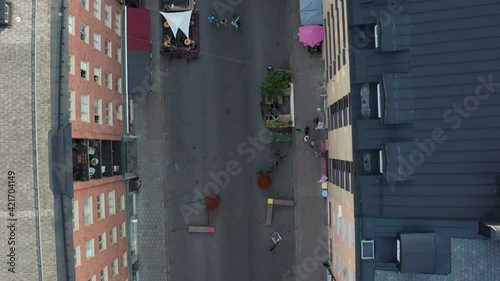 Stockholm, Sweden. Aerial flying drone view of Skånegatan street in SoFo, Södermalm. Summer evening people eating at restaurants and walking.