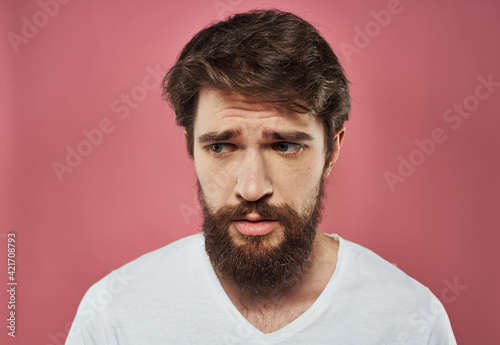 Man with a beard on a pink background sad face emotions model © SHOTPRIME STUDIO
