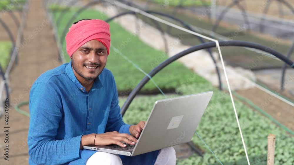 Young indian farmer using laptop at greenhouse or poly house Young indian farmer using laptop at greenhouse or poly house