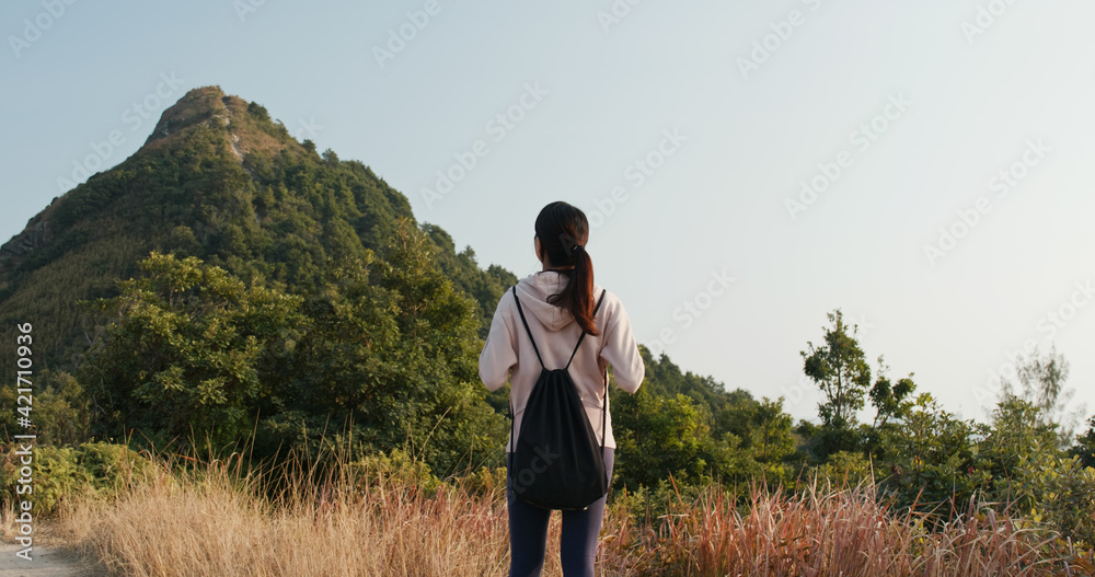 Woman look at the mountain and prepare to hike Woman look at the mountain and prepare to hike