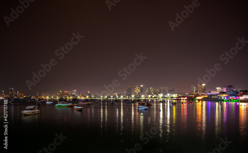 Ships and Ferries in Pattaya City Marina Bay at Night with the City skyline in the background Thailand © Tatiana