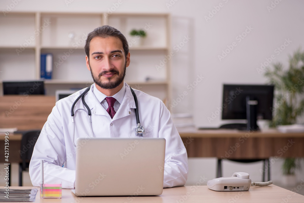 Young male doctor sitting in the office Young male doctor sitting in the office