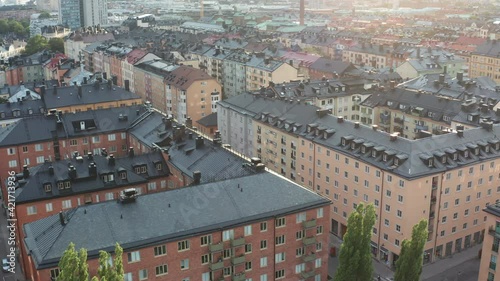 City of Stockholm, Sweden. Panoramic aerial flying drone view of trendy SoFo, district of Södermalm, with Katarinakyrkan, rooftops and town. Beautiful summer evening with the sun.