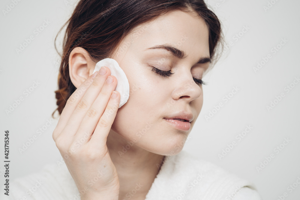 woman wipes her face with a white soft sponge beauty care model