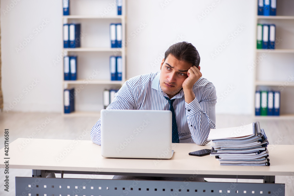 Young male employee working in the office Young male employee working in the office