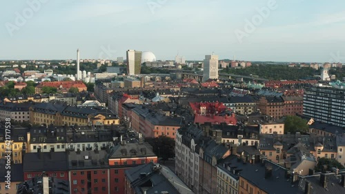 Stockholm, Sweden. Panoramic aerial flying drone view of Södermalm black tin rooftops, trendy SoFo neighbourhood, white globe structure and city. Beautiful summer evening.
