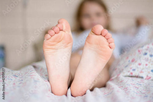 Feet of a little girl on a light background.