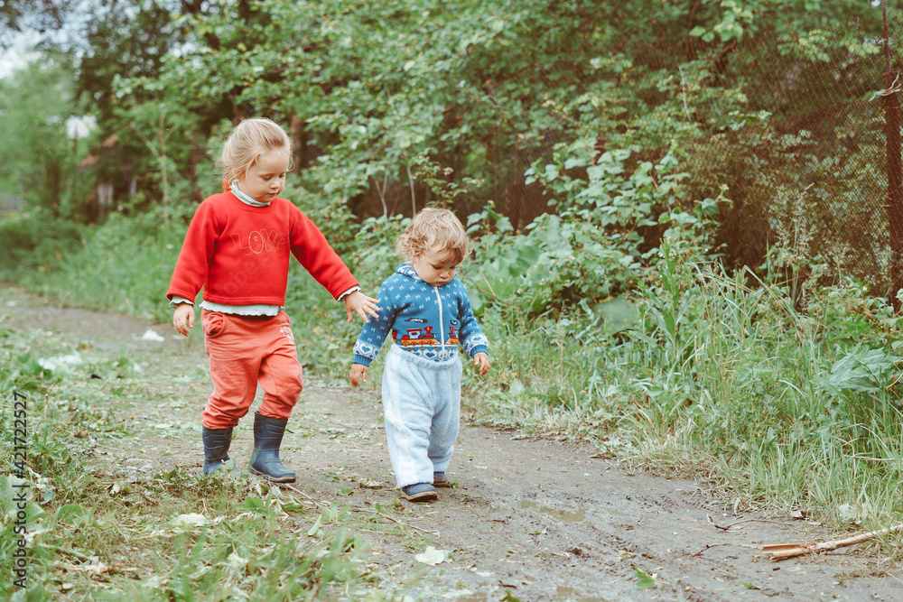 sister and brother walking down the street sister and brother walking down the street