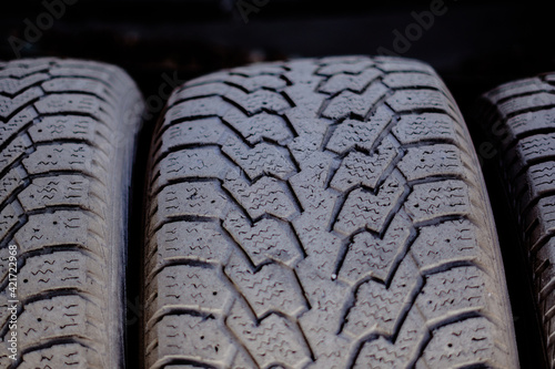 Fotografi Old car tires stand on a metal rack