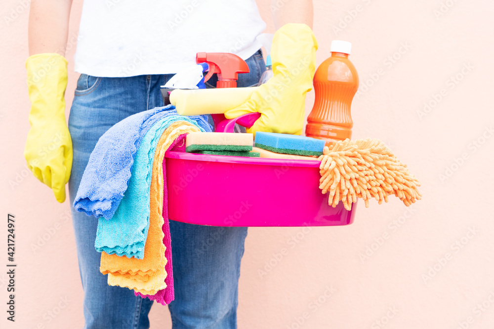 caucasian woman holding basin with cleaning supplies caucasian woman holding basin with cleaning supplies