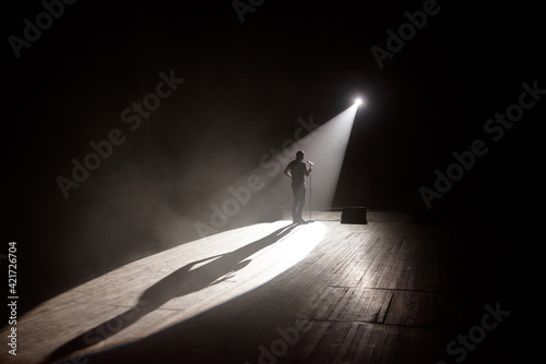 Photography Stand up comedian on stage in the beam of light.
